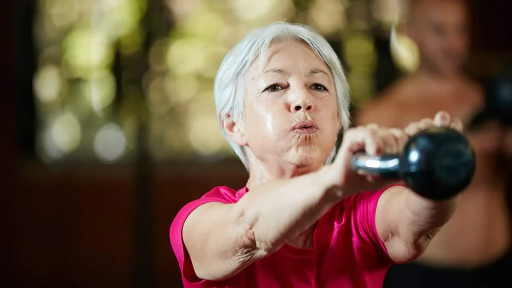 Toning Arms Without the Bulk: Is It Achievable? 1 Woman doing resistance band exercises for toned arms Brackley
